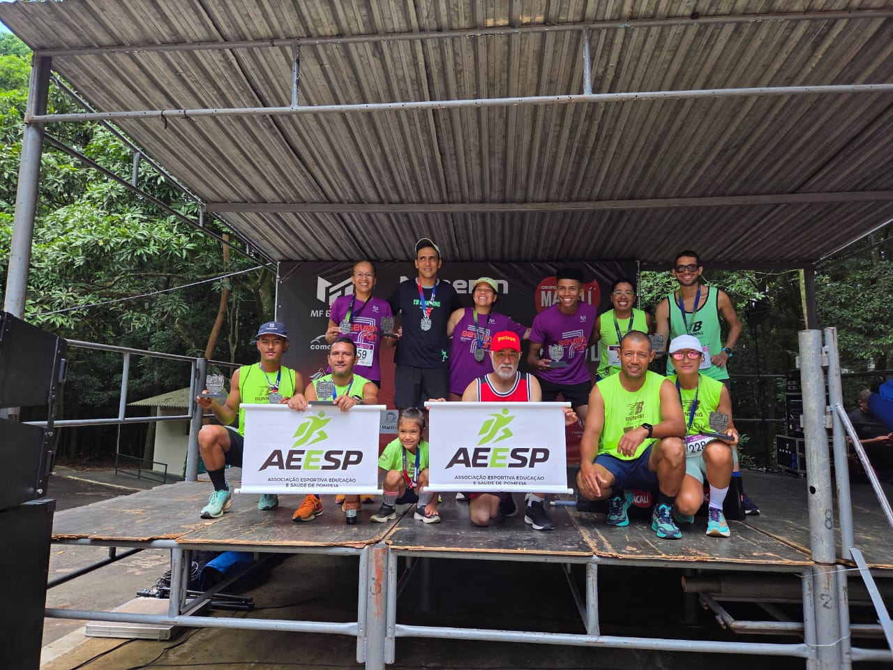 Equipe AEESP no palco com banner